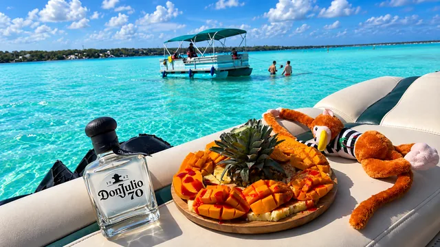 Fruta y una botella sobre el asiento de un pontón frente a la laguna.